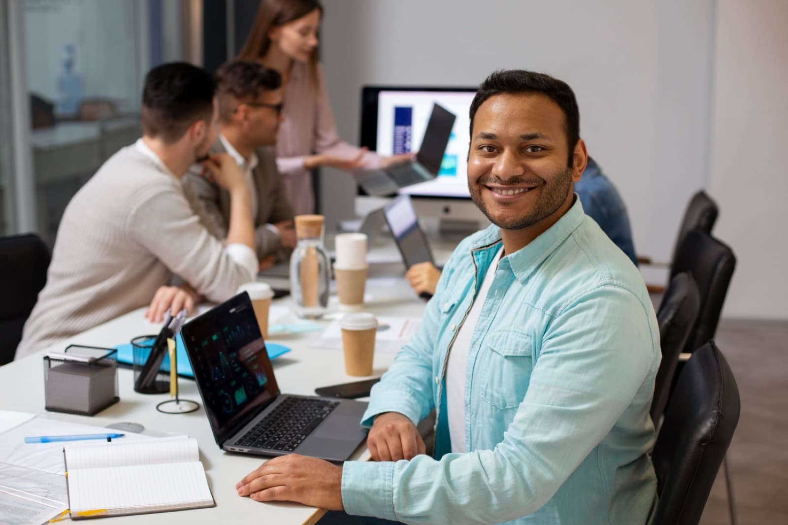 Marketing specialist smiling at a laptop in the office